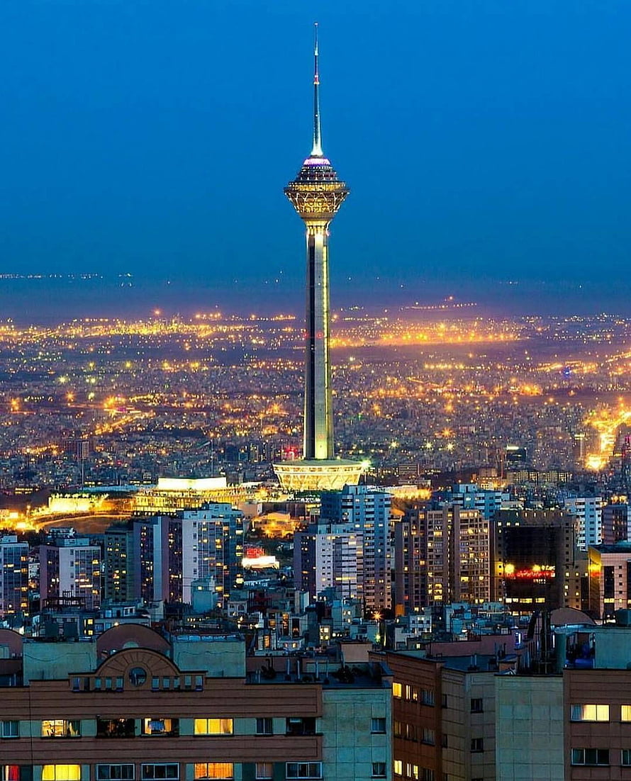 Milad Tower Illuminated at Dusk Over the Tehran Cityscape in Iran HD phone wallpaper
