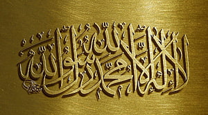 Elegant Gold Arabic Calligraphy on Textured Metallic Background HD wallpaper
