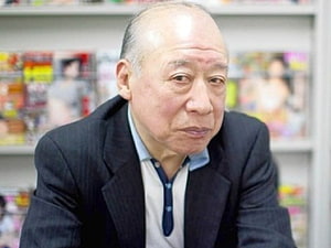 Portrait of an elderly man in a dark suit seated in front of a bookshelf HD wallpaper