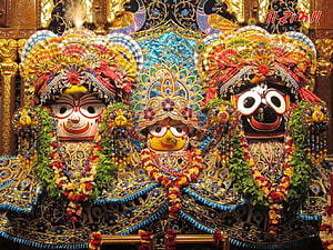 Lord Jagannath Deity with Ornate Headdresses and Floral Garlands in Temple Setting HD wallpaper