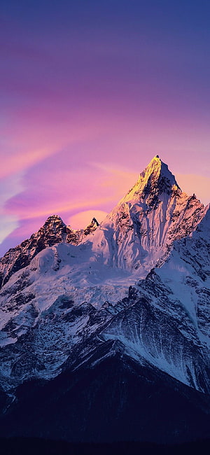 Majestic Snow-Capped Mountain Peak Bathed in Golden Sunset Light Against a Vibrant Purple Sky HD phone wallpaper