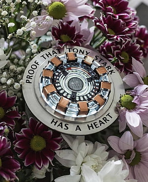 Tony Stark Arc Reactor Model Surrounded by Purple and White Floral Arrangement HD phone wallpaper