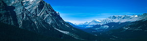 Majestic Snow-Capped Mountain Range Under a Clear Blue Sky HD wallpaper