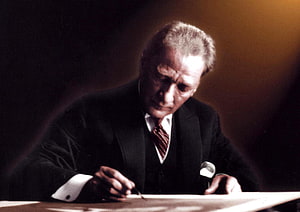 Mustafa Kemal Atatürk Writing at a Desk in a Formal Black Suit HD wallpaper