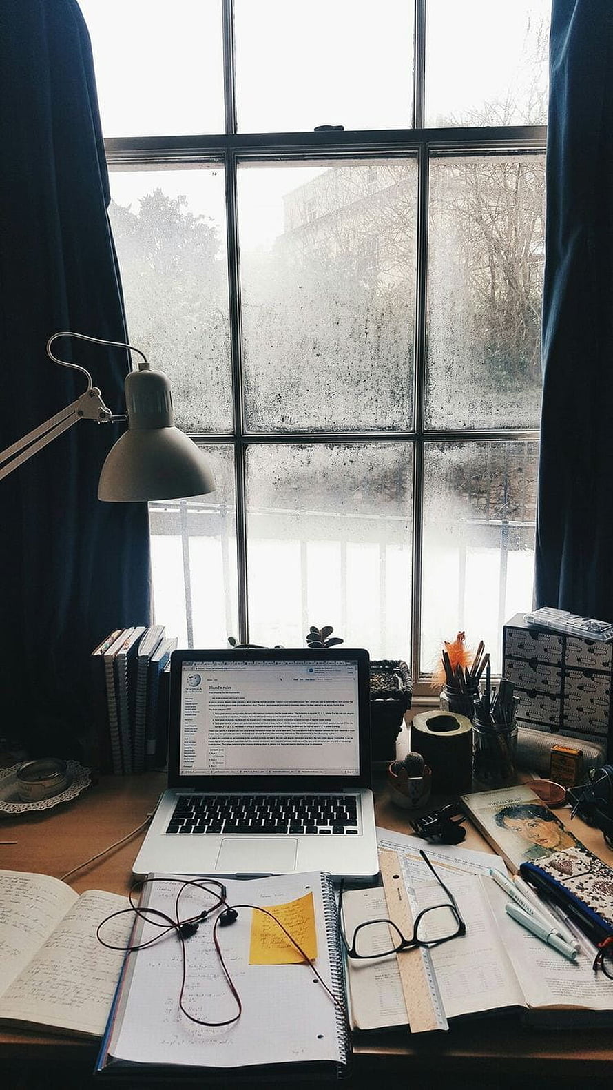 Cozy Study Desk Setup with Laptop, Notebooks, and Desk Lamp by a Foggy Window HD phone wallpaper