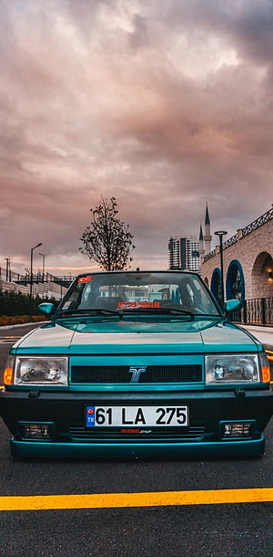 Turquoise Tofas Dogan SLX Front View Under Dramatic Sunset Sky HD phone wallpaper