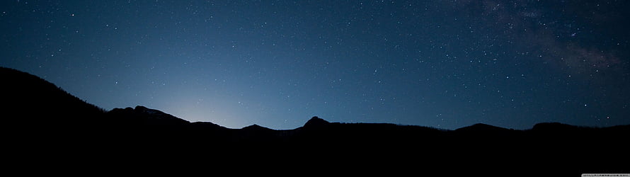 Starry Night Sky Over Mountain Silhouette With Milky Way and Deep Blue Horizon HD wallpaper