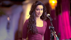 Shraddha Kapoor performing on stage in Aashiqui 2 with microphone and warm lighting HD wallpaper