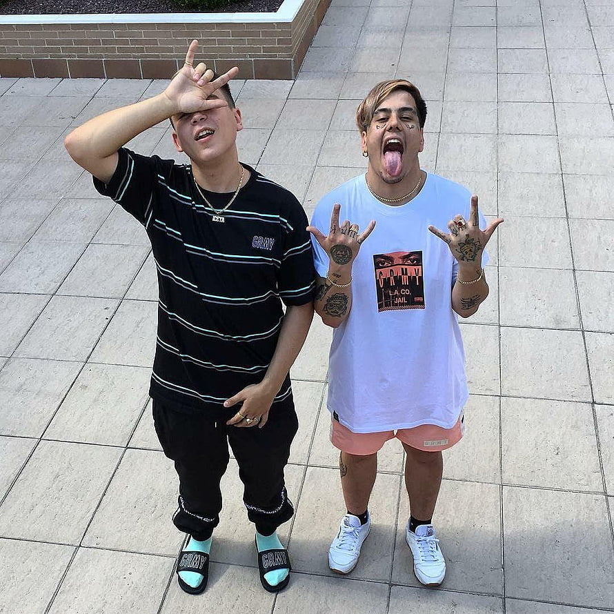 Duki and YSY A posing with hand gestures on a paved plaza HD phone wallpaper
