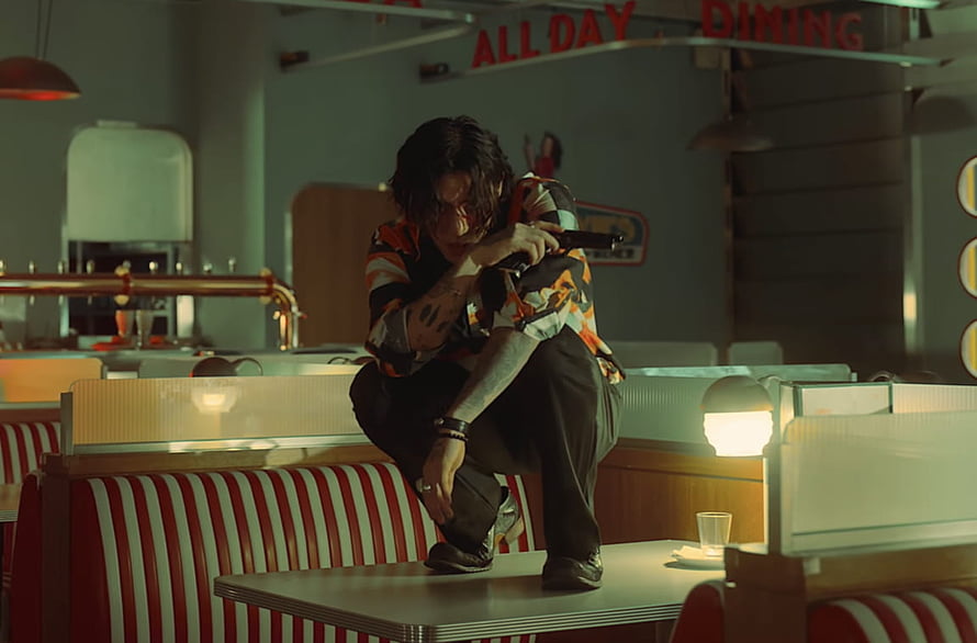 DPR Ian in a moody retro diner scene holding a pistol with cinematic lighting HD wallpaper