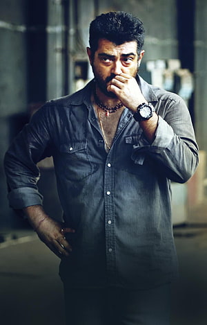 Ajith Kumar in a moody portrait wearing a dark button-up shirt with a serious expression HD phone wallpaper