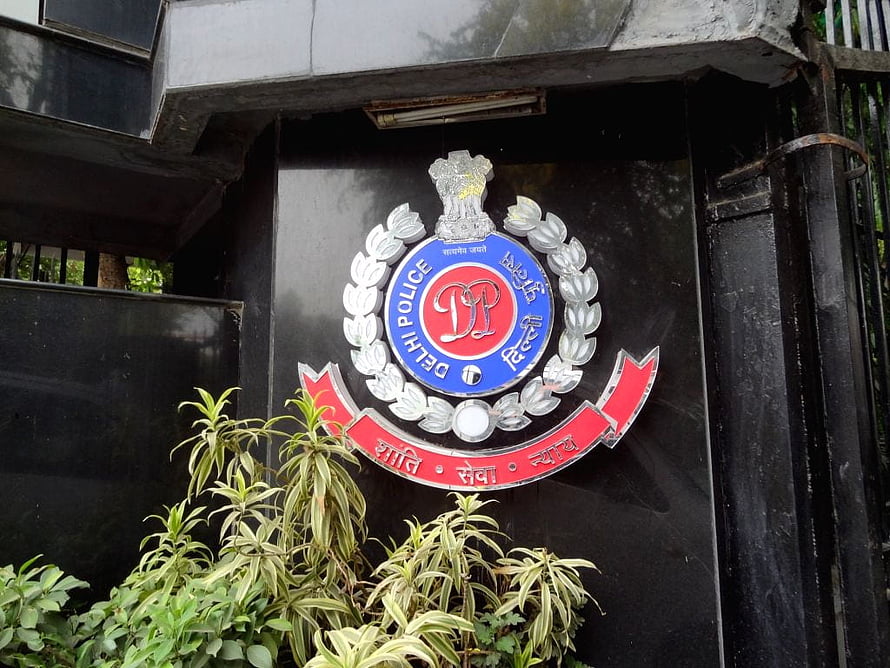 Delhi Police Emblem Mounted on Black Wall with Green Foliage HD wallpaper