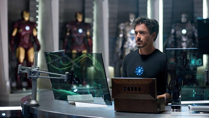 Tony Stark in the Iron Man Lab with Holographic Displays and Armor Suits HD wallpaper