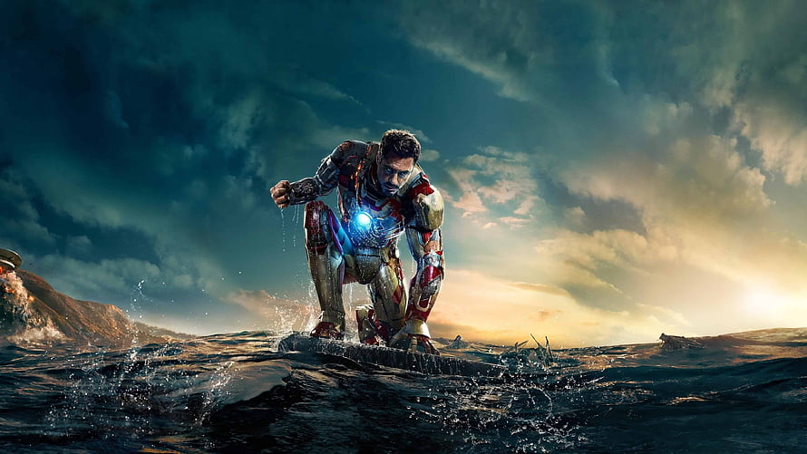 Iron Man 3 Tony Stark in Damaged Armor Crouching on Rocky Shore at Sunset HD wallpaper