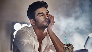 Sushant Singh Rajput in a contemplative pose with a white shirt and iced coffee HD wallpaper