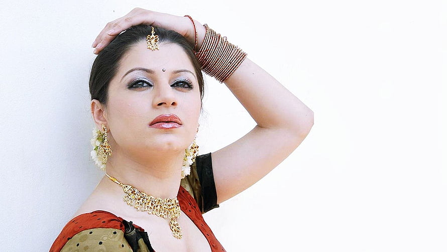 Elegant Indian Woman in Traditional Saree with Gold Jewelry and Floral Earrings HD wallpaper
