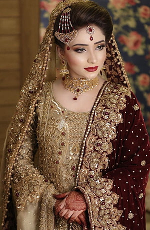 Elegant Pakistani Bride in Gold and Maroon Embroidered Bridal Lehenga with Traditional Jewelry HD phone wallpaper