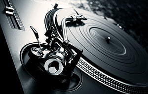 Close-up of a professional DJ turntable with vinyl record and tonearm in monochrome HD wallpaper