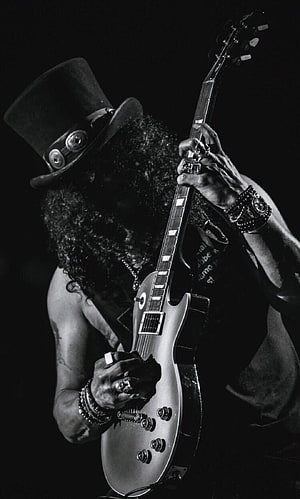 Slash from Guns N' Roses playing electric guitar in a black and white portrait HD phone wallpaper