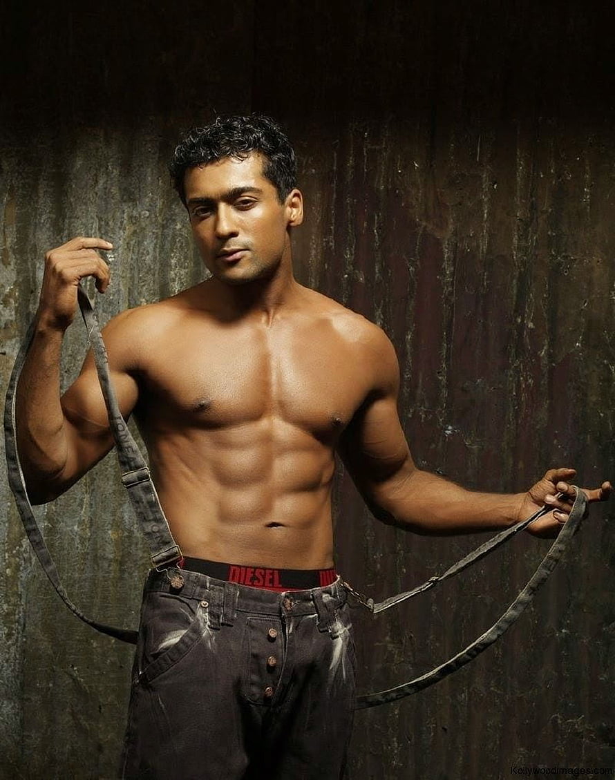 Surya shirtless studio portrait with suspenders and dark jeans against a textured wall HD phone wallpaper