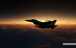 Silhouetted Jet Fighter Soaring Above Clouds at Sunset HD wallpaper