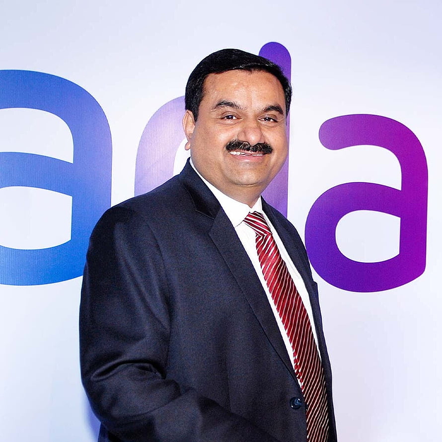 Gautam Adani in a dark suit and red striped tie standing before a corporate backdrop HD phone wallpaper