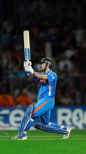 MS Dhoni in Indian cricket kit executing a powerful batting stroke on the field HD phone wallpaper