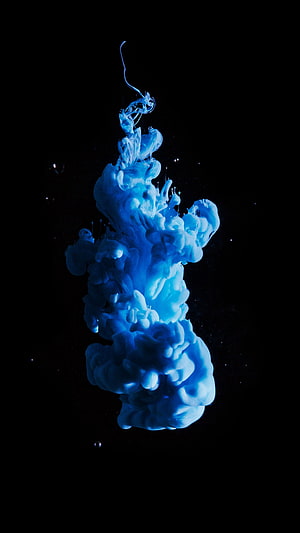 Vibrant Blue Ink Diffusing in Water Against a Deep Black Background HD phone wallpaper