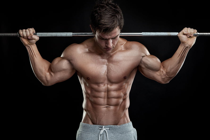 Muscular Man Performing Barbell Shoulder Press in Dark Studio Setting HD wallpaper