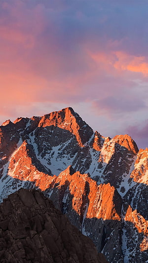 Alpine Mountain Peak Bathed in Golden Sunset Light with Snowy Ridges and Pink Sky HD phone wallpaper