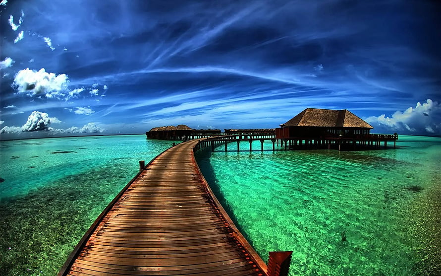 Tropical Overwater Bungalows Connected by a Long Wooden Boardwalk Over Turquoise Lagoon Water HD wallpaper