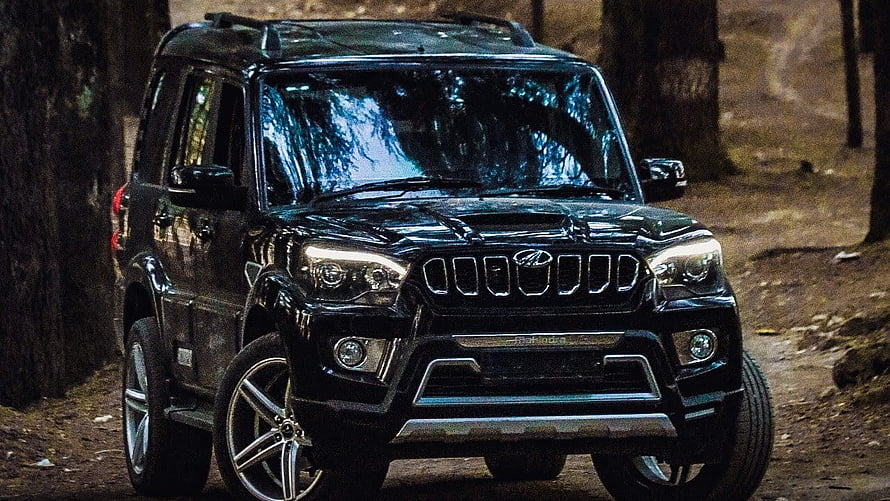 Black Mahindra Scorpio S11 SUV parked on a forest trail with rugged off-road styling HD wallpaper
