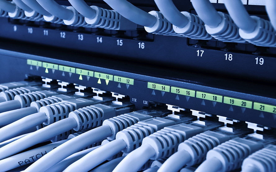 Close-up of Ethernet patch cables plugged into a network switch with numbered ports and green indicator lights HD wallpaper