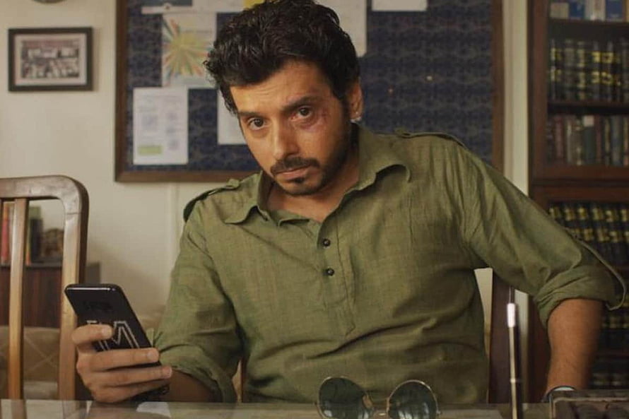 Divyendu Sharma as Munna Bhaiya in Mirzapur holding a smartphone in an office setting HD wallpaper