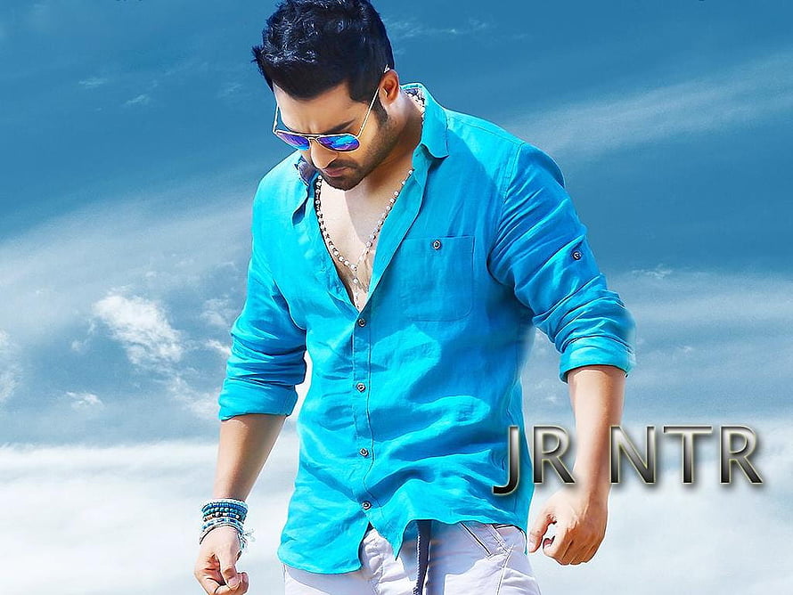 Jr NTR in a bright blue shirt and sunglasses against a clear sky HD wallpaper