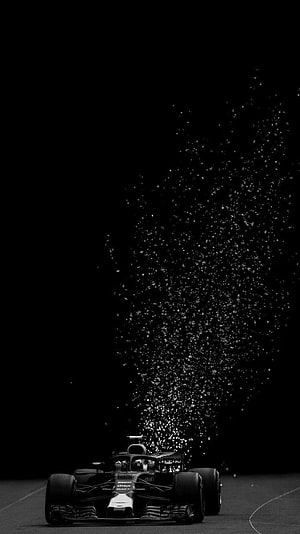 Formula 1 Race Car Emitting Sparks on Dark Track at Night HD phone wallpaper