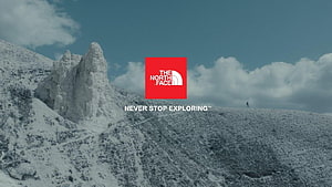 The North Face Snowy Mountain Landscape with Rock Formation and Hiker HD wallpaper