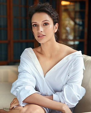 Tripti Dimri in a White Off-Shoulder Shirt Sitting on a Beige Sofa HD phone wallpaper