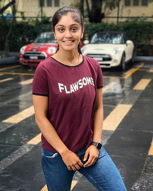 Harleen Deol in Maroon Flawsome Tee and Blue Jeans in a Parking Lot HD phone wallpaper