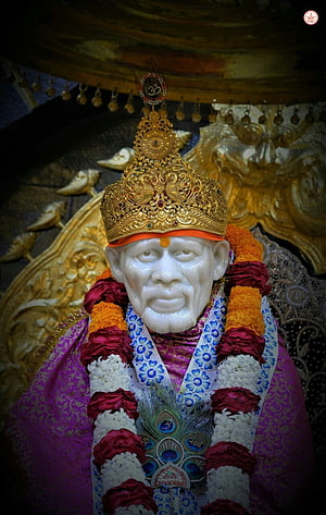 Sai Baba Murti with Golden Crown and Flower Garland in Temple Setting HD phone wallpaper
