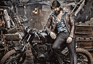 Yash as Rocky in KGF Chapter 2 promotional still on a vintage motorcycle in a gritty scrapyard setting HD wallpaper