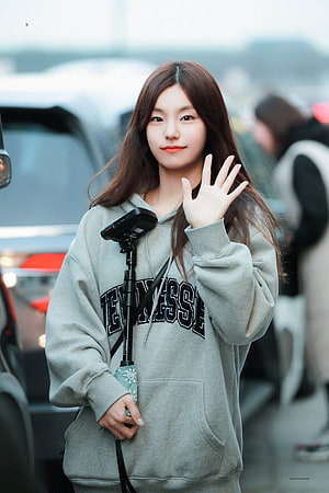 Hwang Yeji from ITZY Waving in a Grey Hoodie at an Airport HD phone wallpaper