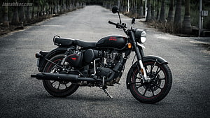 Royal Enfield Classic 350 Stealth Black Motorcycle Parked on a Tree-Lined Road HD wallpaper