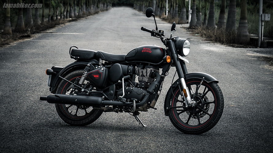 Royal Enfield Classic 350 Stealth Black Motorcycle Parked on a Tree-Lined Road HD wallpaper