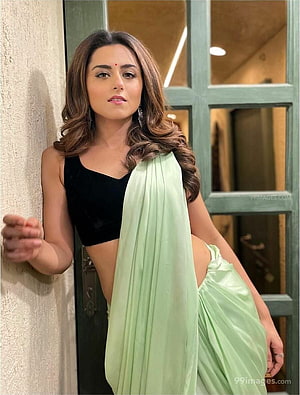 Ridhi Dogra in a mint green saree and black crop top posing by a doorway HD phone wallpaper