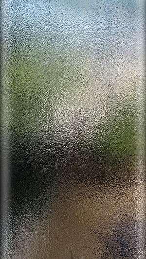 Raindrops on Textured Glass with Soft Green and Amber Light HD phone wallpaper