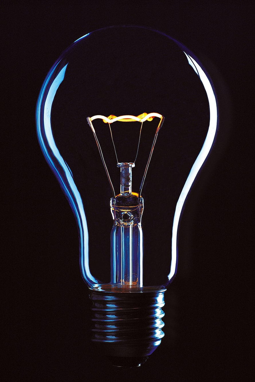 Glowing Incandescent Light Bulb with Visible Filament on Black Background HD phone wallpaper