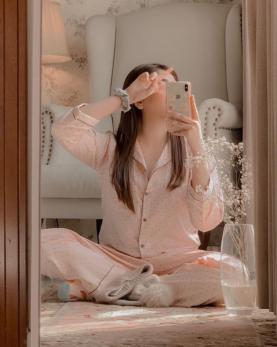 Woman in Pink Polka Dot Pajamas Taking a Mirror Selfie in a Cozy Bedroom HD phone wallpaper