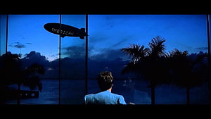 Scarface Movie Scene: Man Watching Blimp Over Tropical Coast at Dusk HD wallpaper
