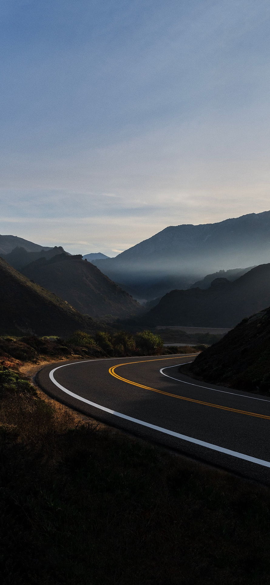 Winding Mountain Road at Dawn with Misty Valley and Blue Sky HD phone wallpaper